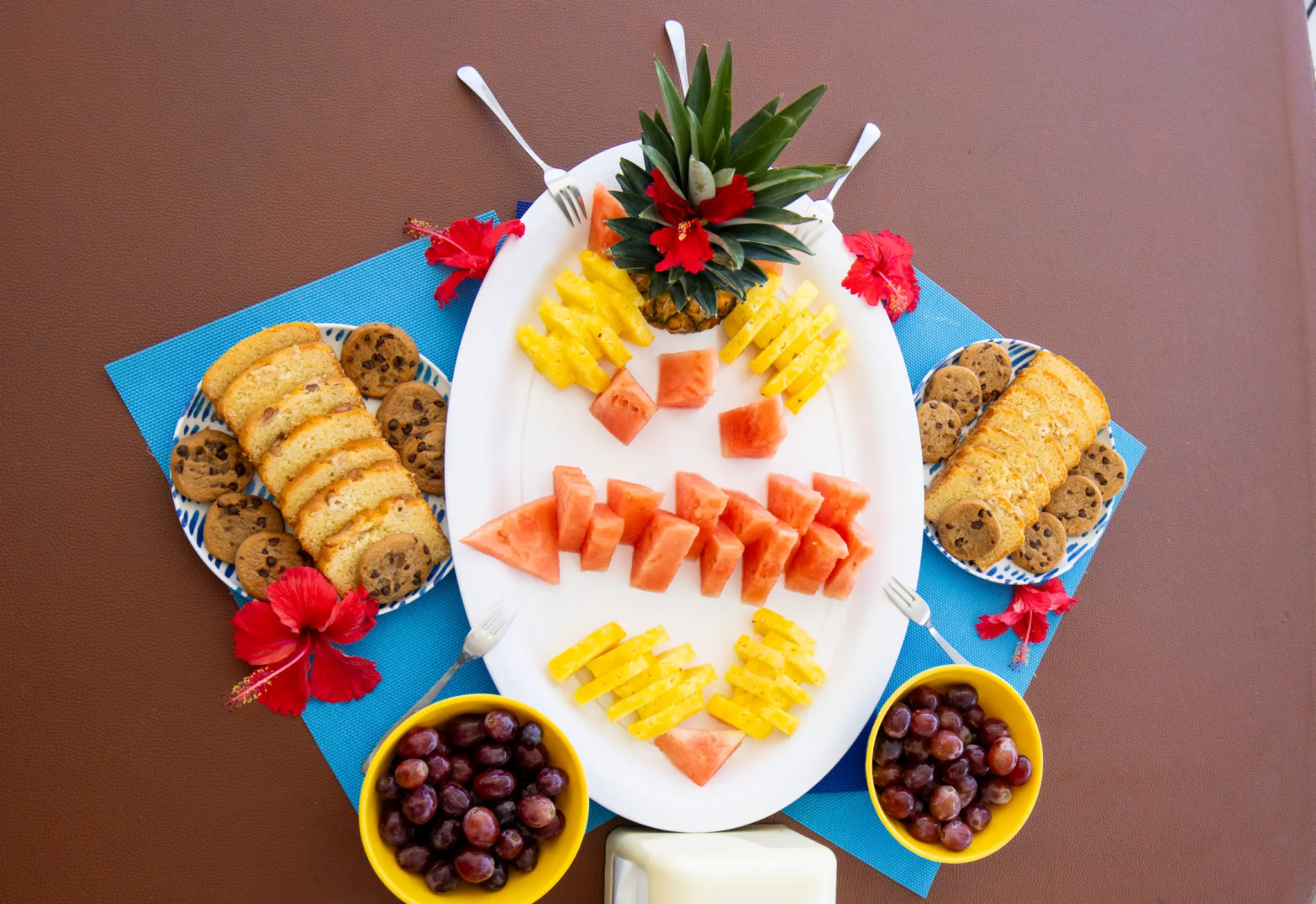 Overhead view of tropical fruit spread with pineapple, papaya and cookies aboard The Phoenix