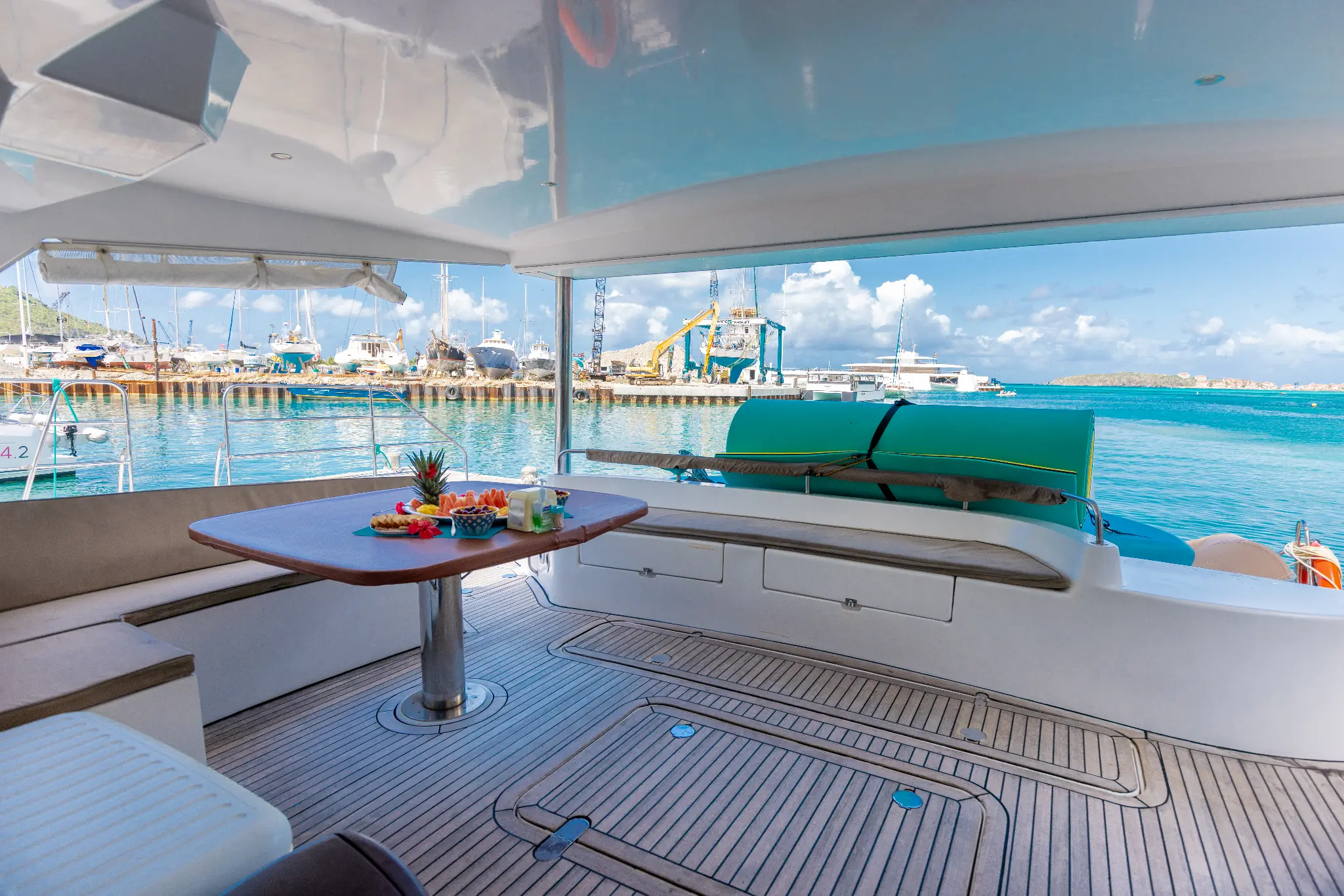 The Phoenix catamaran cockpit dining area with fruit platter, Bobby's Marina