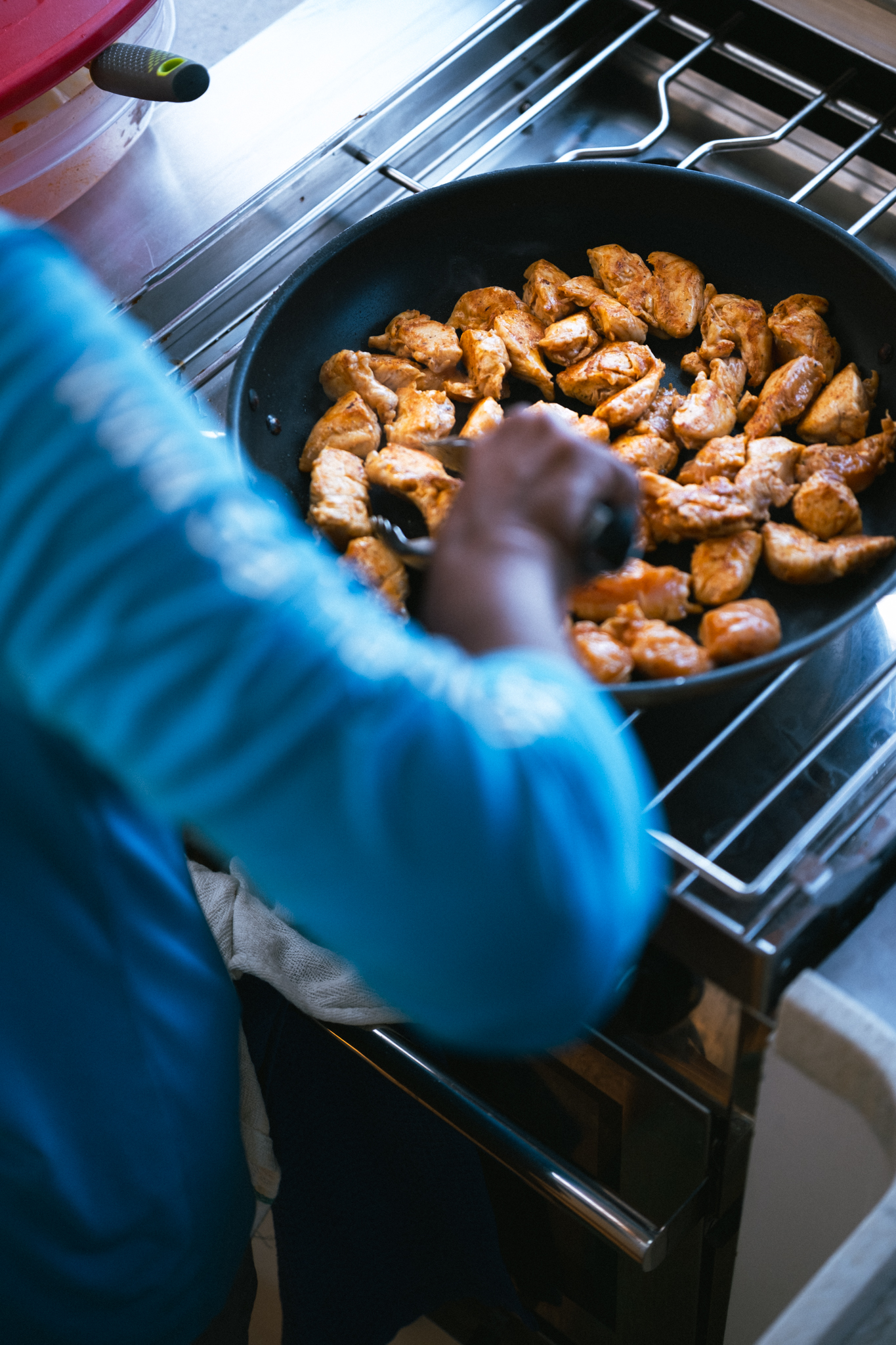 Chef Camille cooking chicken in The Phoenix galley kitchen aboard the catamaran