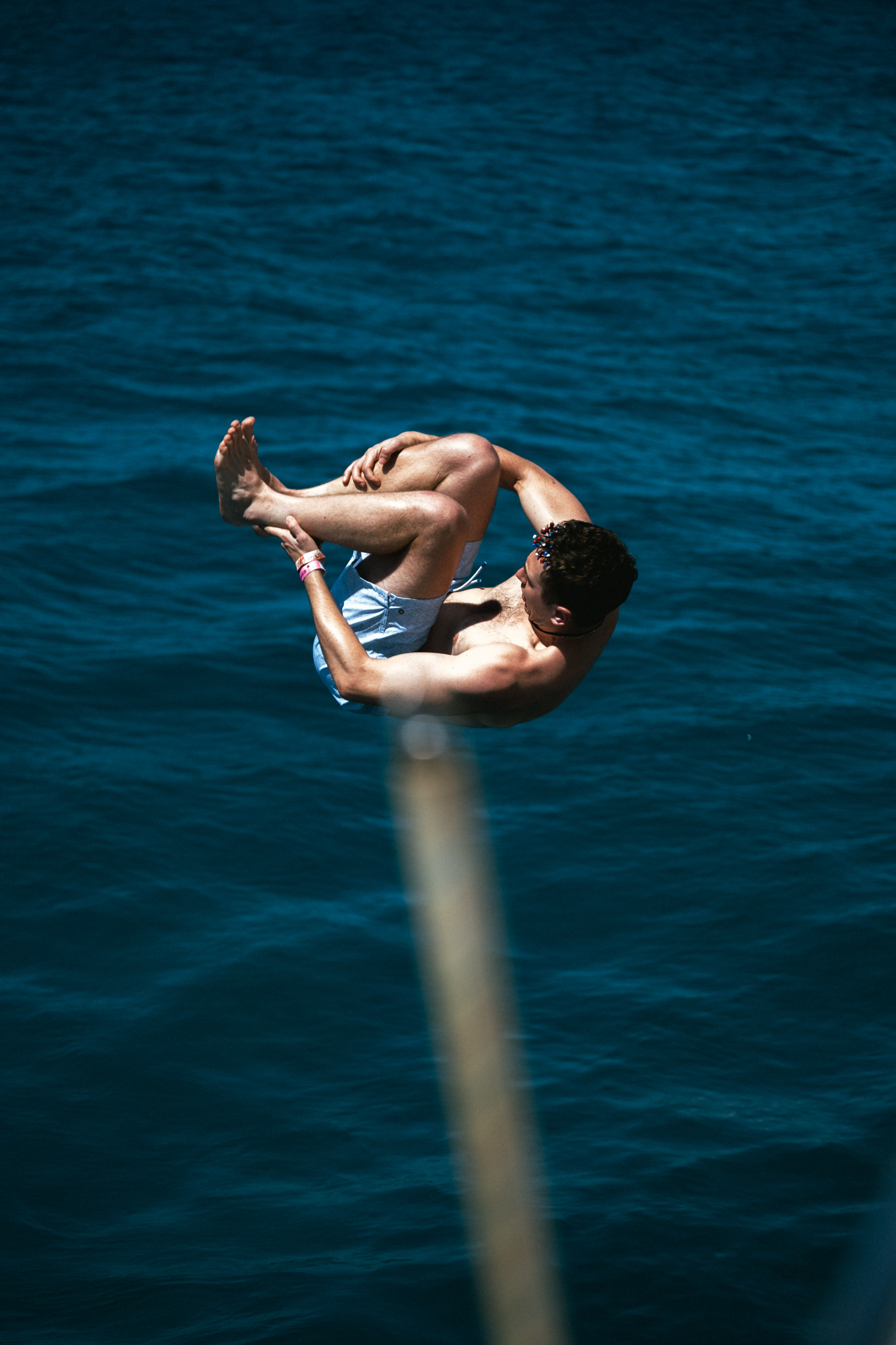 Guest doing a backflip off The Phoenix catamaran into the deep blue Caribbean Sea