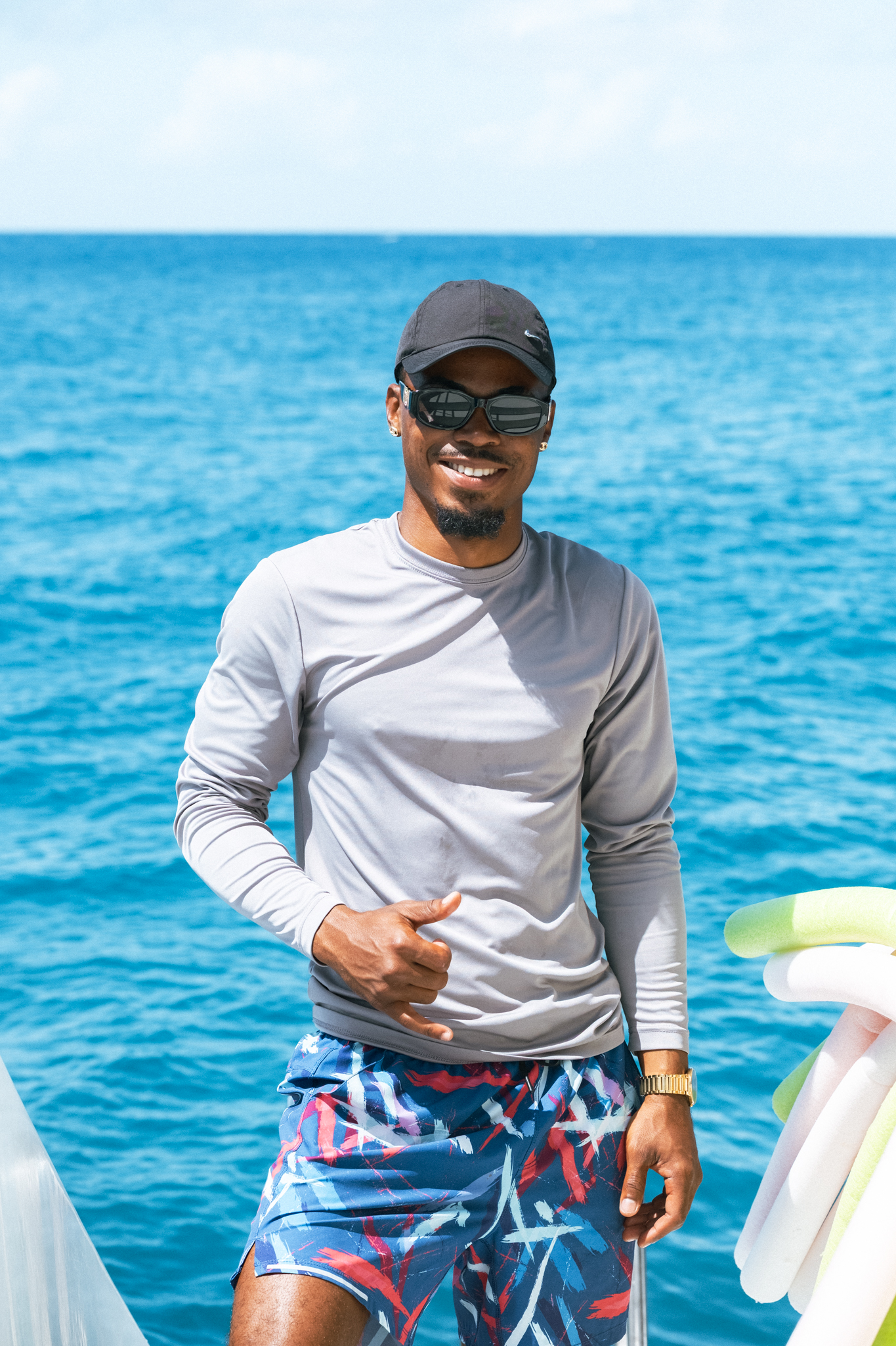 Crew member smiling aboard The Phoenix catamaran with turquoise Caribbean Sea in the background