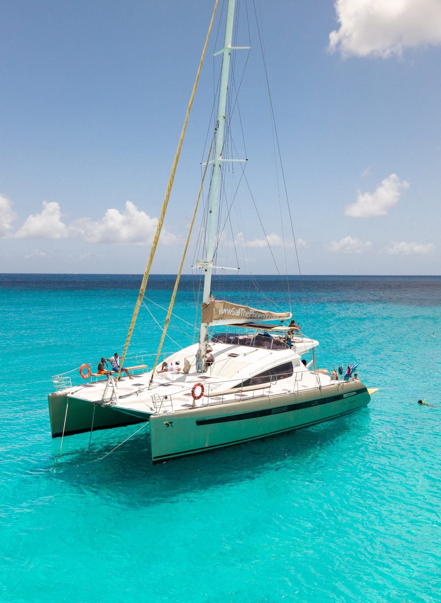 The Phoenix catamaran anchored in crystal-clear turquoise water, St. Maarten