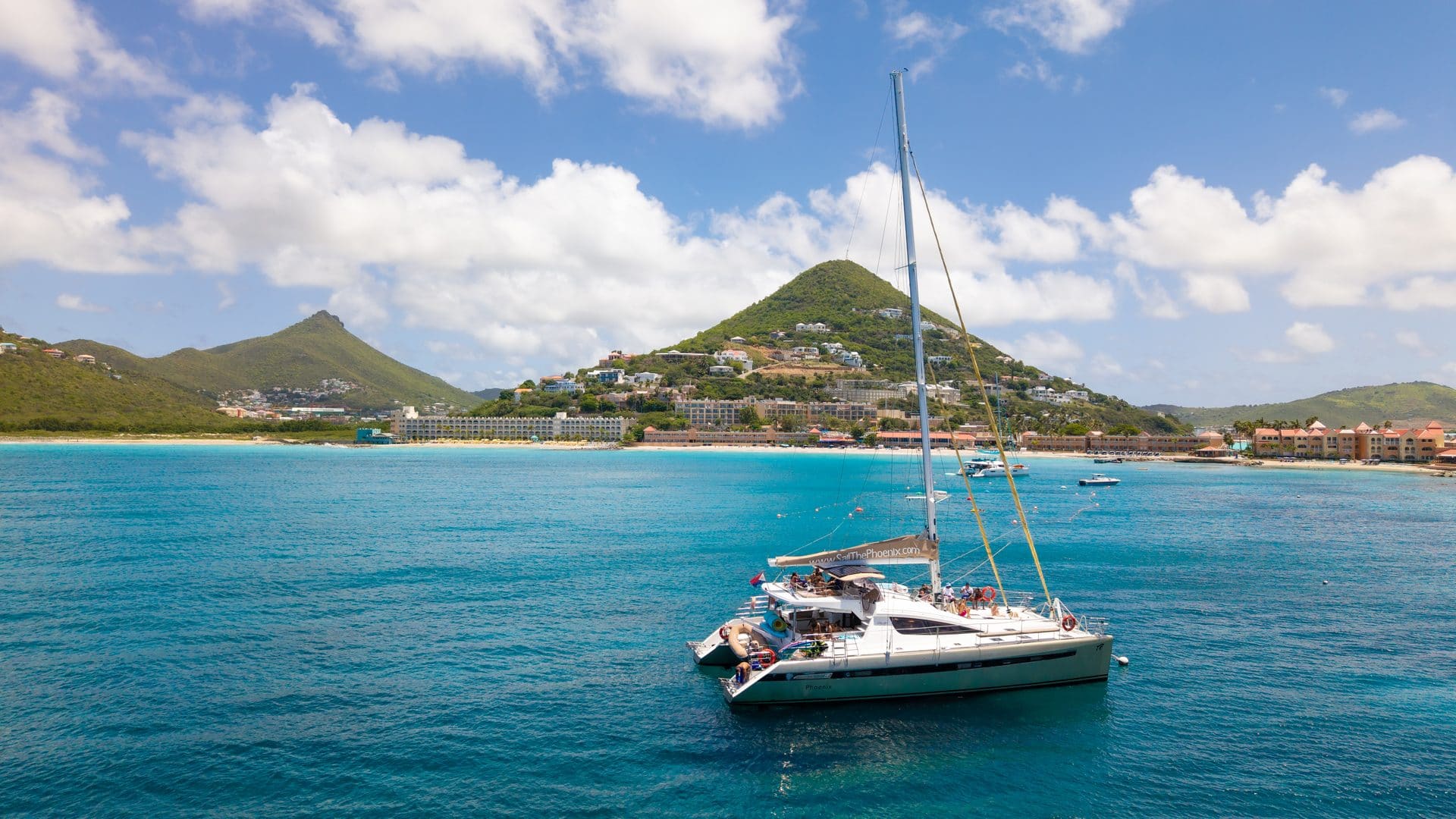 Aerial view of The Phoenix catamaran sailing along the St. Maarten coastline